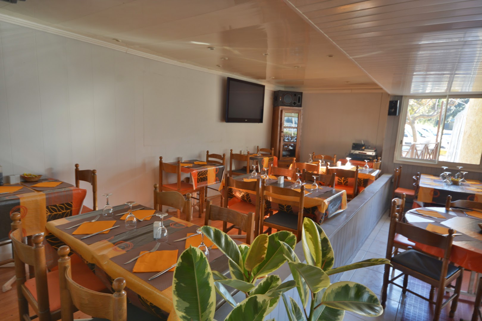 La salle aux tables orangées avec une grande fenêtre